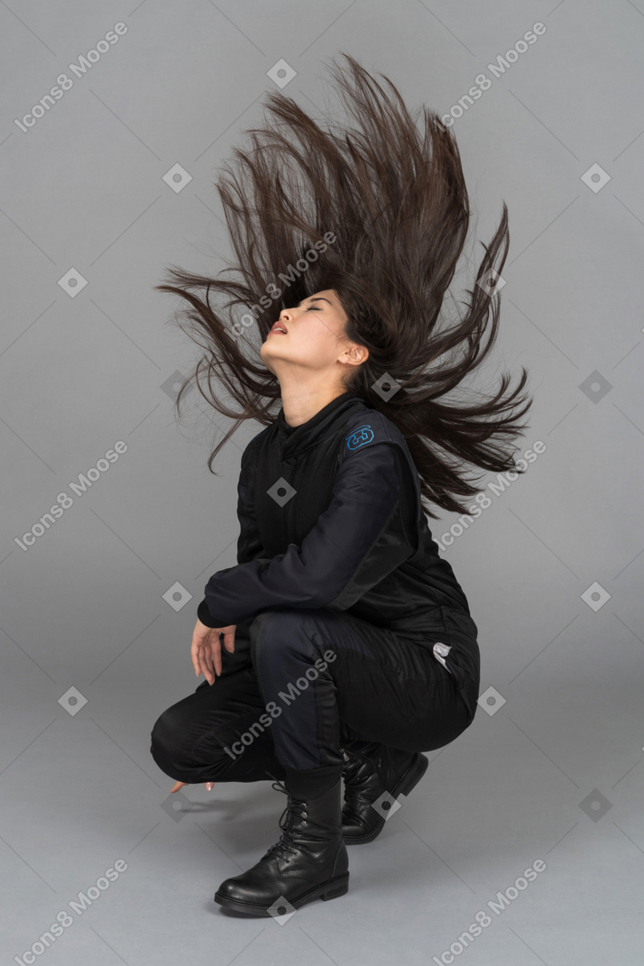 Красивая молодая женщина позирует с волосами в воздухе
