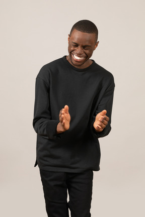 Young man clapping hands and laughing