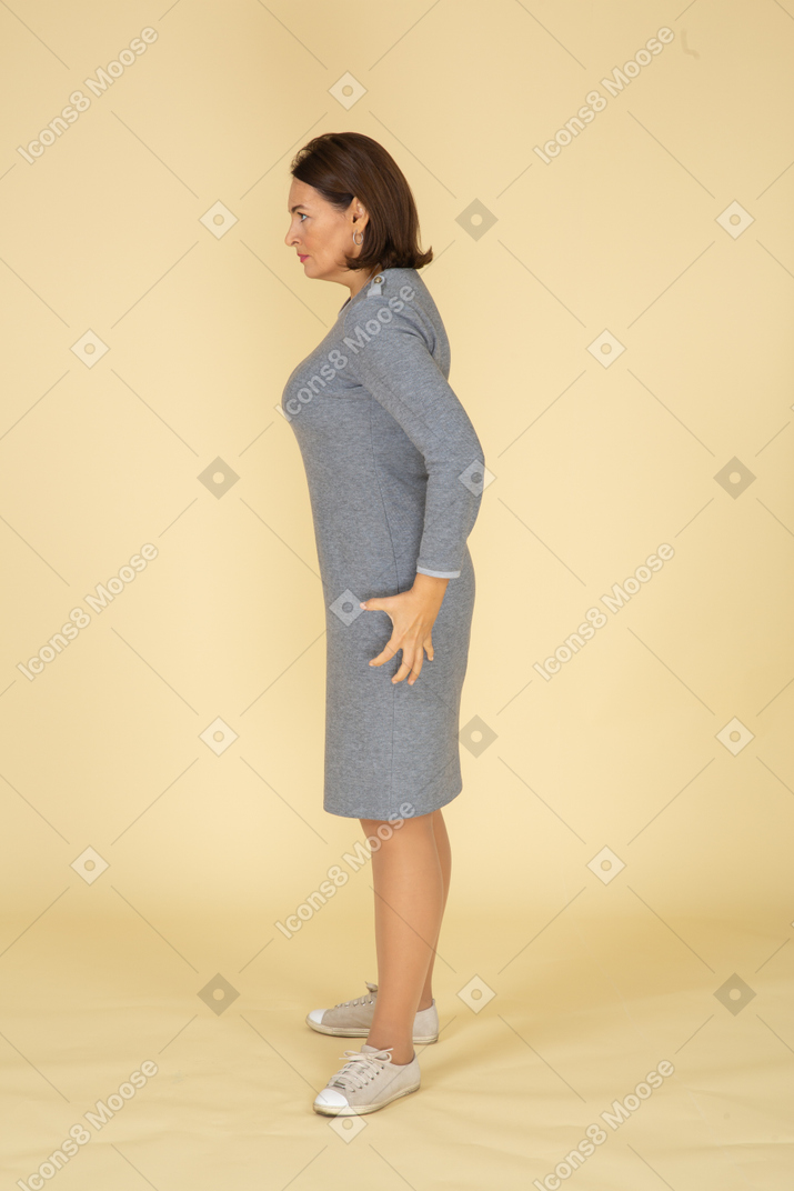 站在侧面的灰色连衣裙的女人