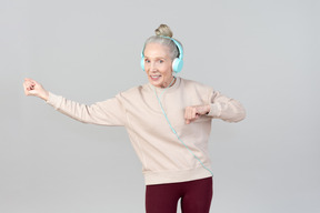 Old lady in listening music in headphones