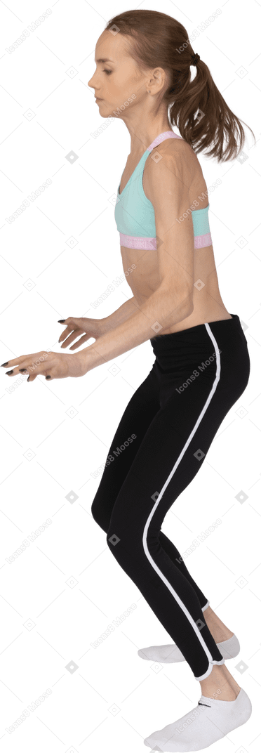 Vista lateral de uma adolescente em roupas esportivas pulando