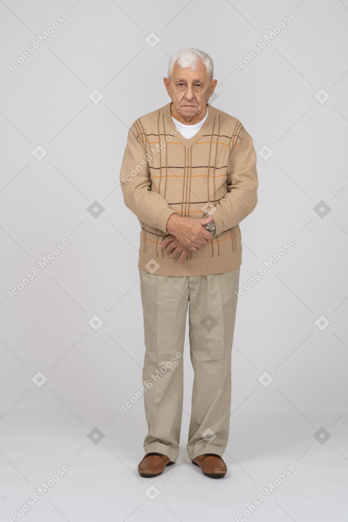 Вид спереди на старика в повседневной одежде, смотрящего в камеру