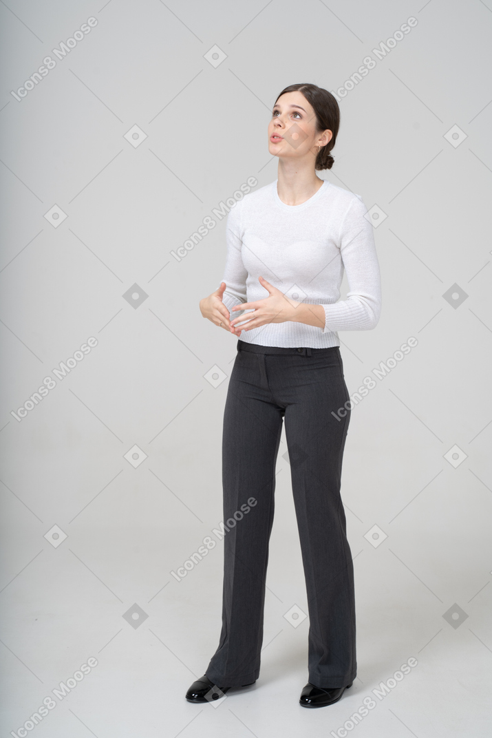 見上げるスーツを着た若い女性の正面図