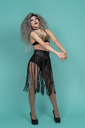 Drag queen in all black outfit stretching arms