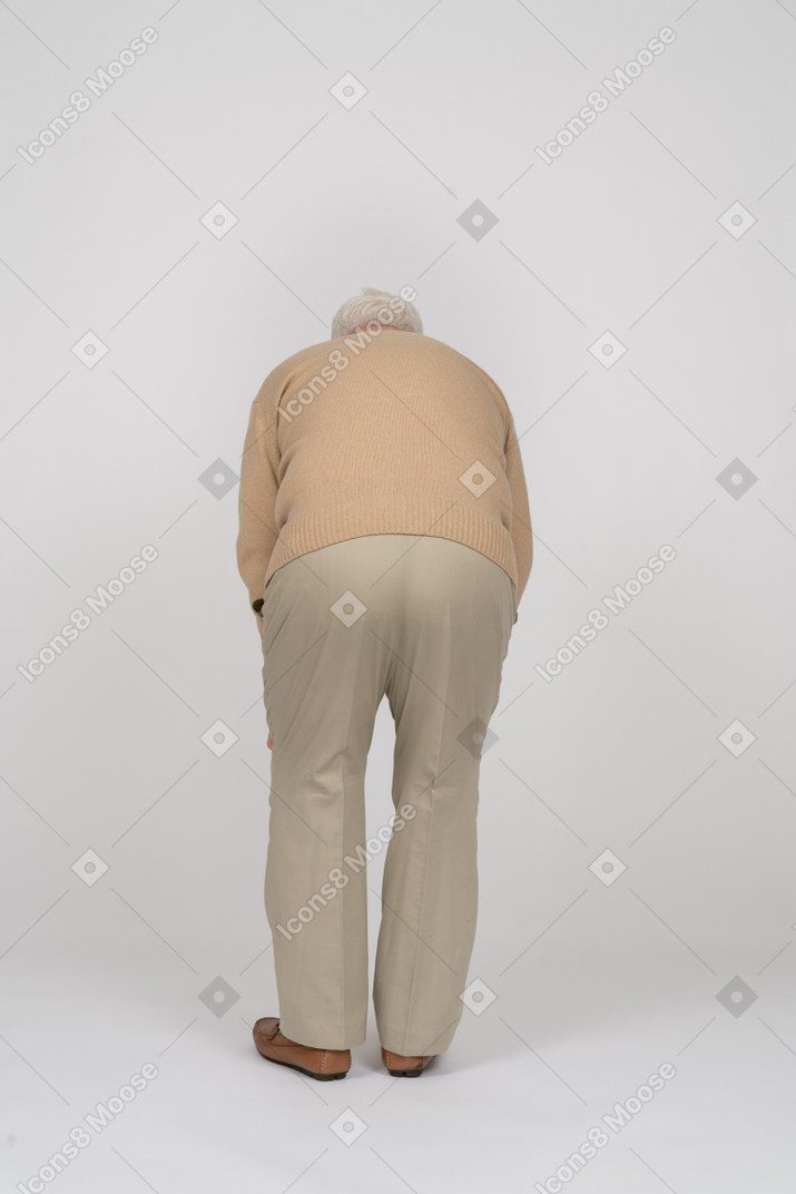 Vista posteriore di un vecchio in abiti casual chinarsi
