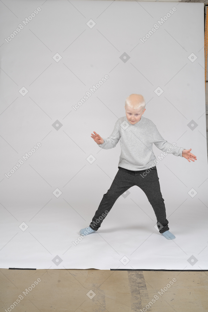 Boy in casual clothes raising hands