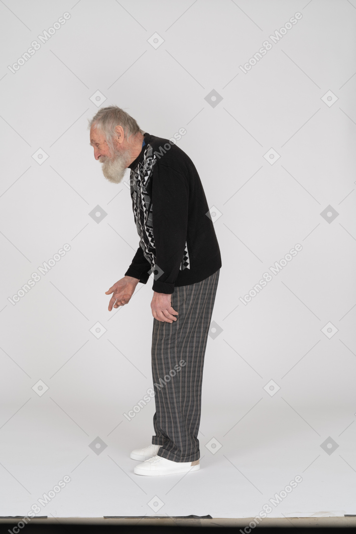 Side view of old man looking down and speaking