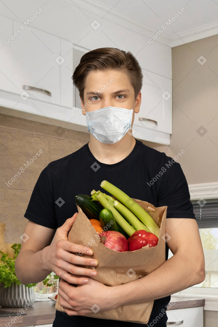 A man holding a bag of vegetables
