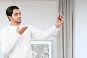 Man blowing kiss and taking selfie