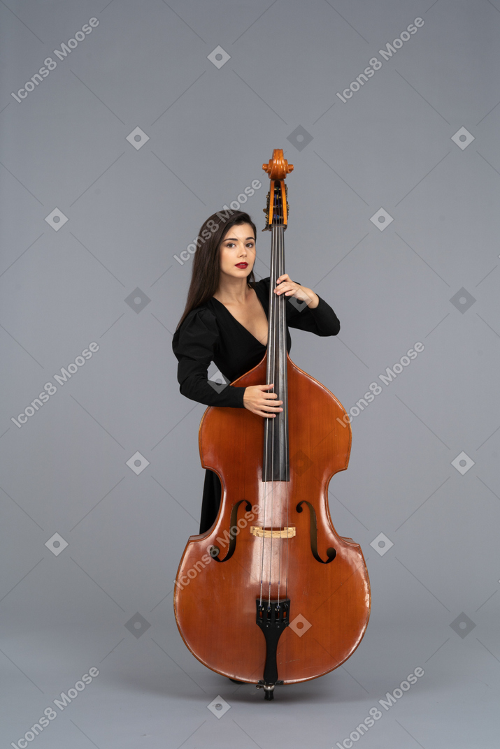 Front view of a young woman in black dress playing her double-bass