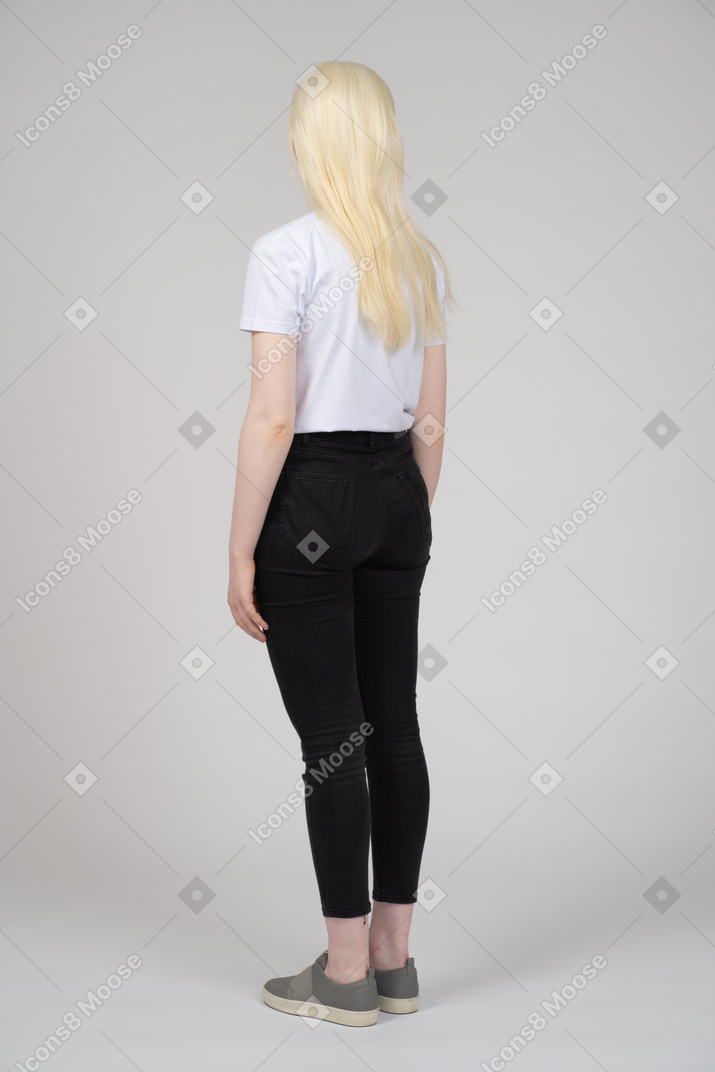 Vista posteriore di tre quarti di una ragazza adolescente con le braccia ai lati