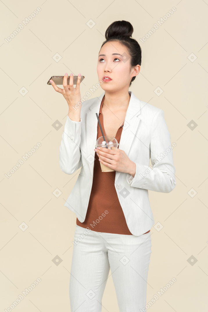 Dissatisfied young asian office employee listening to phone and having phone