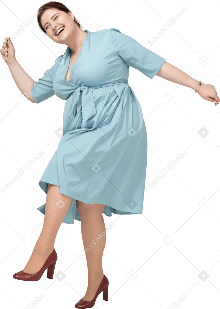 Вид спереди счастливой женщины в синем платье, балансирующей на одной ноге