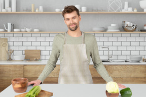 A man standing in front of a counter in a kitchen