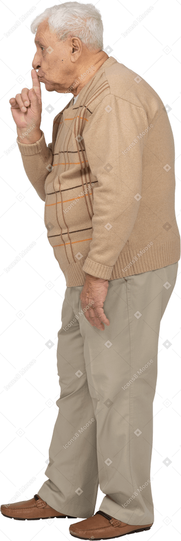 一个穿着休闲服的老人做嘘手势的侧视图