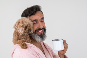 Cute puppy sitting on his master's shoulder