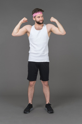 Jovem em forma demonstrando os músculos do braço