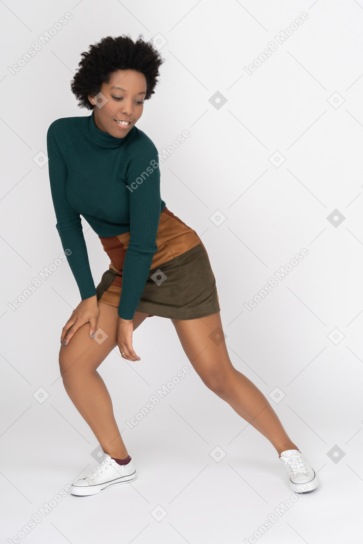 Flexible smiling teenage girl bending knees