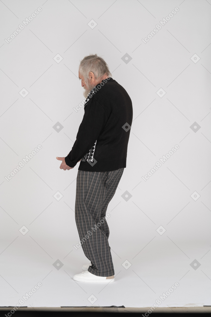 Vista lateral del anciano agachado y gesticulando