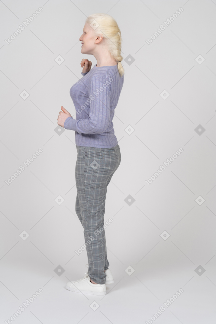 Young woman standing with bent arms