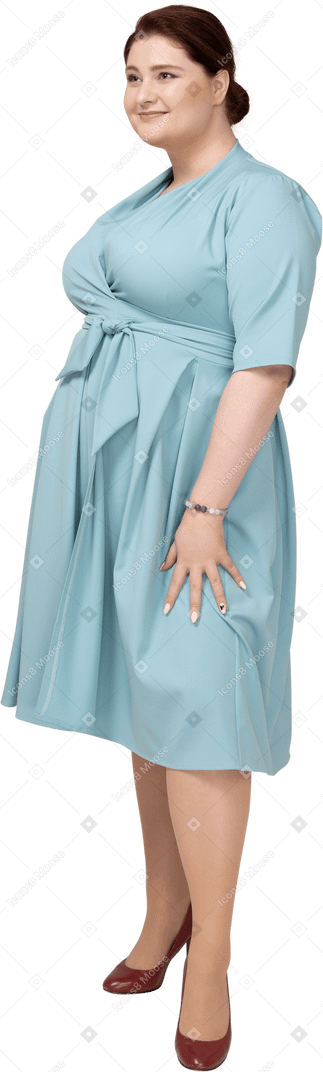 Woman in blue dress standing in profile