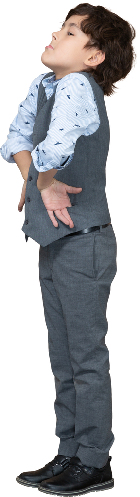 Vista laterale di un ragazzo in giacca e cravatta in posa con le mani sui fianchi