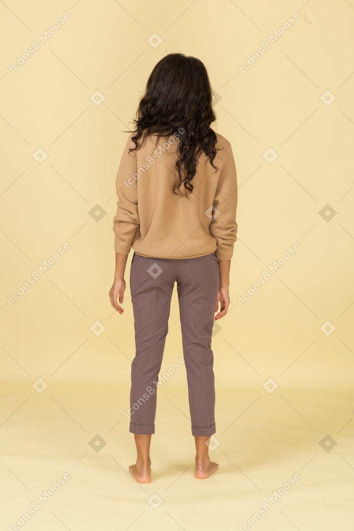 Back view of a dark-haired unknown female in casual clothes
