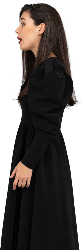 Vista laterale di una giovane donna che canta in un abito nero