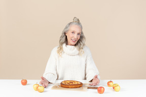 Elegant old woman offering to try her freshly baked apple pie