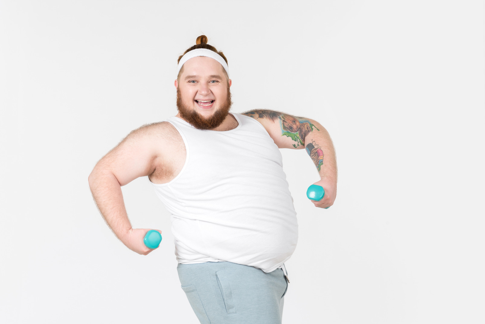 Laughing big guy in sportswear lifting hand weights