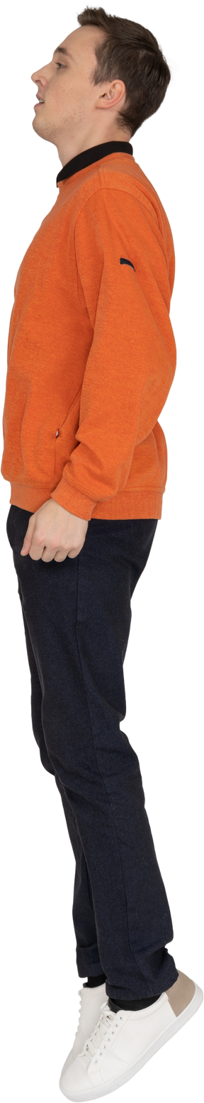 Jeune homme en sweat-shirt orange sautant