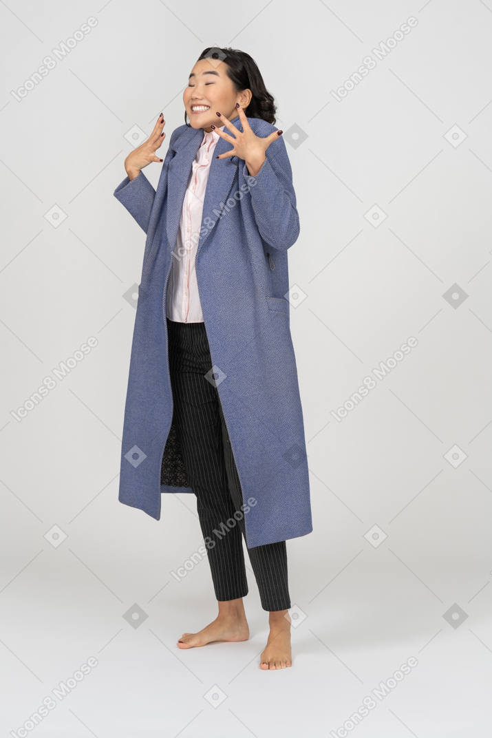 ジェスチャーをするコートを着た興奮した女性