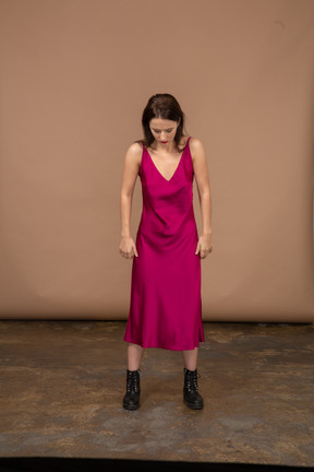 Front view of a young woman in beautiful red dress looking down