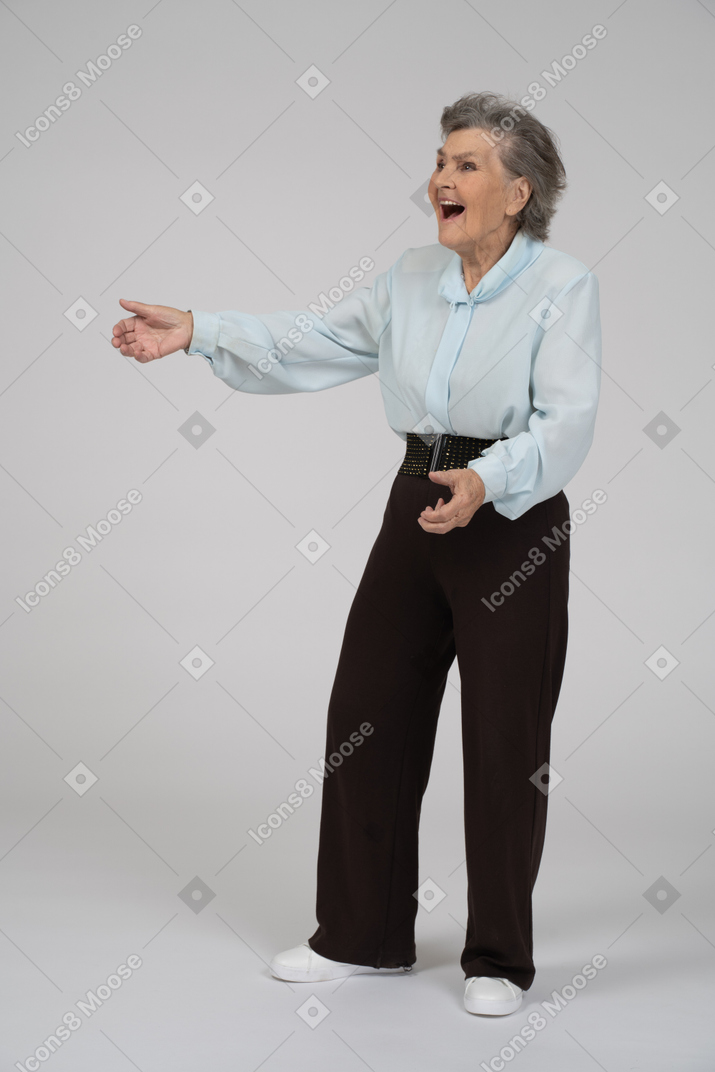 Vue de trois quarts d'une vieille femme gesticulant avec enthousiasme