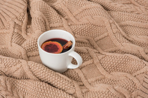 Tasse glühwein auf gestrickter decke