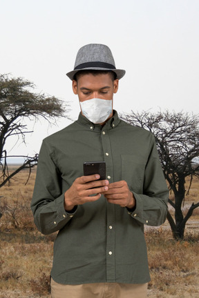 A man with face mask looking at his phone