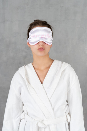 Woman in bathrobe with sleep mask on