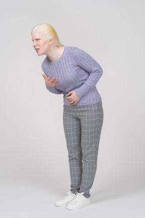 Young woman bending down and groaning with stomachache