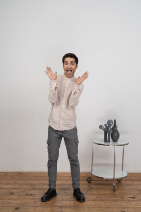 Front view of a happy man in casual clothes gesturing