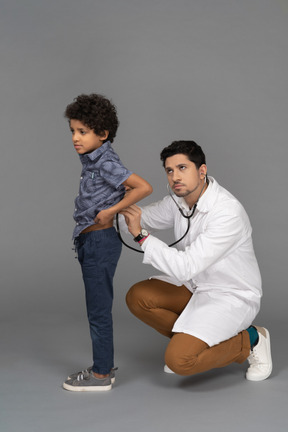 Médico examinando garotinho