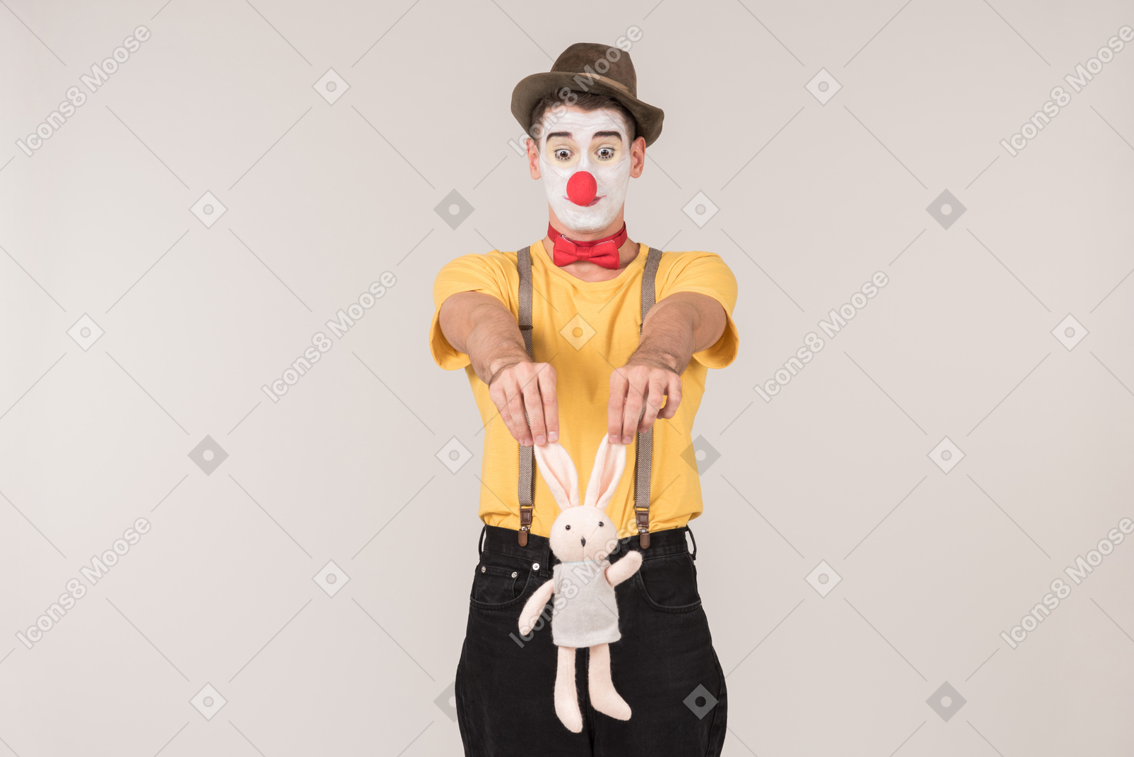 Male clown holding toy rabbit