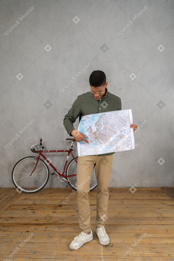 一名男子拿着并指着地图的正面图
