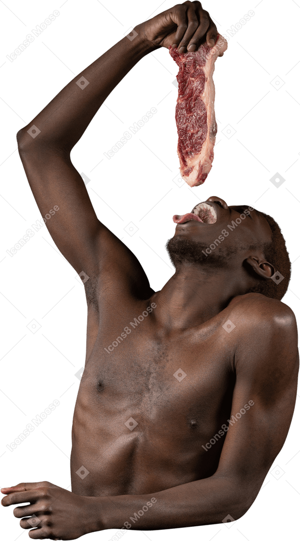 Front view of a young afro man holding a slice of meat while opening mouth wide