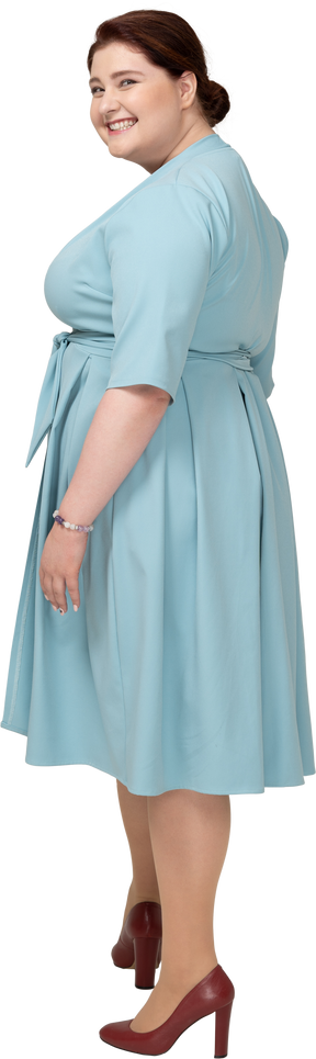 Vue latérale d'une femme heureuse en robe bleue