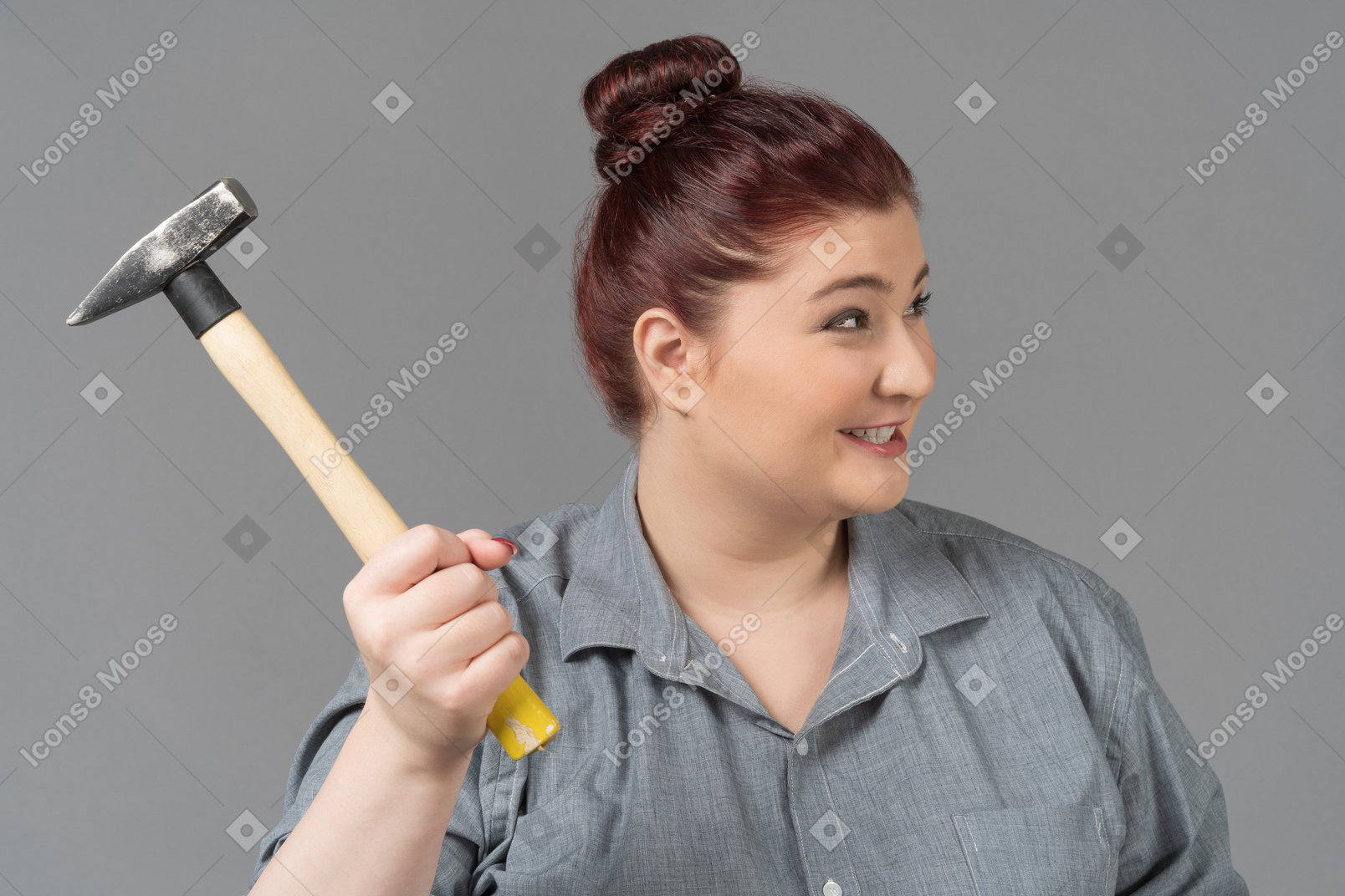 Cheerful woman threatening with hammer
