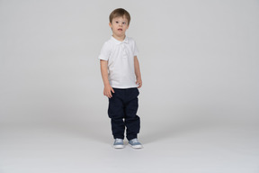 Front view of little boy standing and looking aside