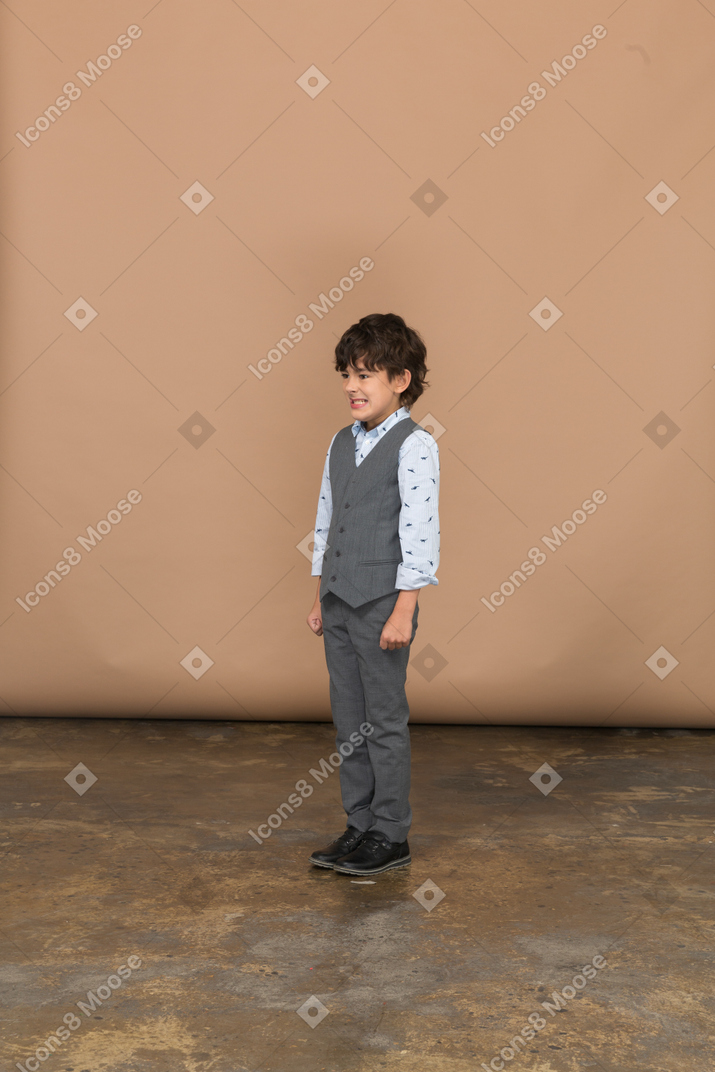 Vista frontal de un niño feliz en traje