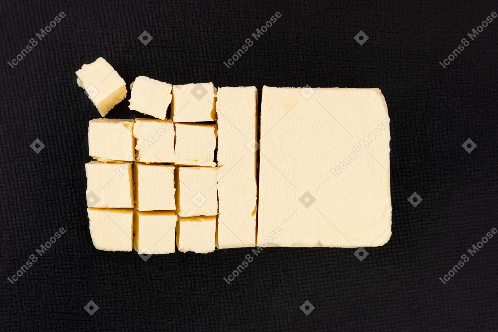Cut block of butter on black background