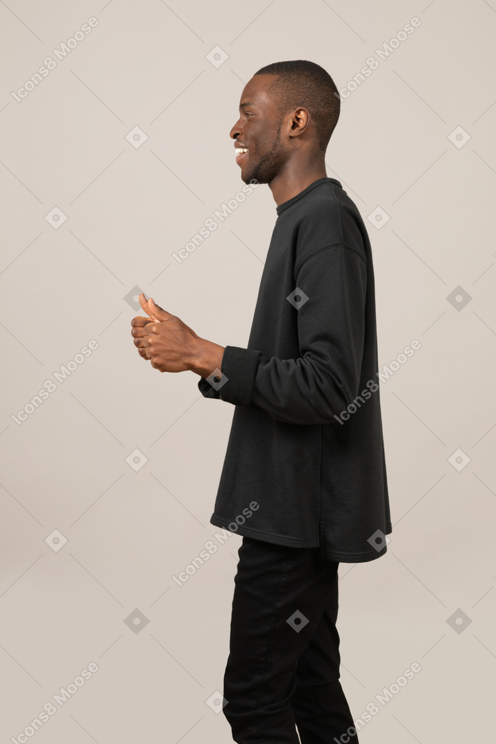 Side view of a young man with two thumbs up