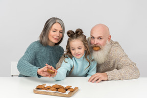 Grand-père ne peut pas arrêter de rigoler et grand-mère empêche l'enfant d'avoir un autre cookie